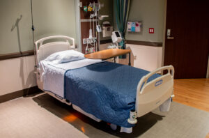 One hospital bed in a room with bathroom access